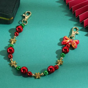 Christmas beaded bag charm detail, gold clasps, red green beads and festive snowflake design.