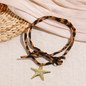 Leopard print silk scarf necklace featuring gold starfish pendant for autumn style.