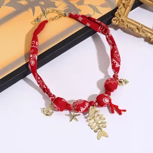 Red paisley fabric necklace with gold fish skeleton starfish charms for beach holiday.