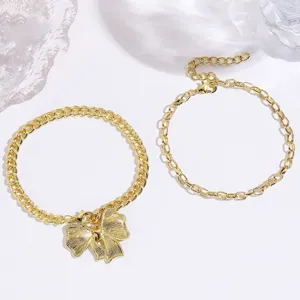 Gold metal chain necklace and bracelet set featuring a delicate bow pendant and extension link.