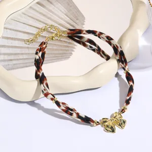Close-up detail view of double-layer choker necklace featuring leopard fabric and bow.