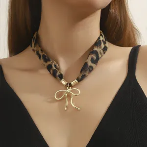 Leopard print fabric choker necklace with gold metal bow pendant detail view fashion jewelry