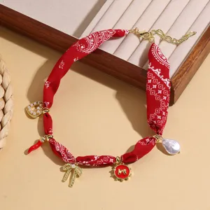 Red paisley fabric necklace with pearls and multi-element pendants, chic braided design for women.