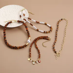 Detail view of retro brown bead and pearl necklaces set with chic gold chains and charms.