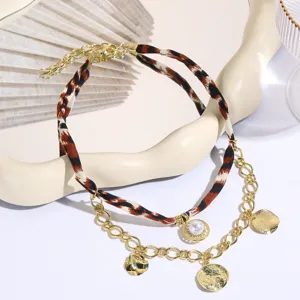 Exquisite double layer leopard print fabric and gold chain necklace with pearl and coin pendants.