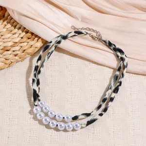 Close-up detail view of the double-strand leopard print fabric and faux pearl necklace.