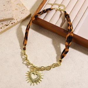 Chic leopard print silk scarf and gold chain necklace featuring a sun pendant detail.