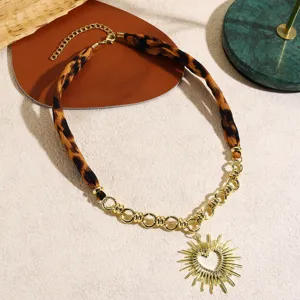 French vintage leopard print fabric and gold chain necklace with sun heart pendant detail.