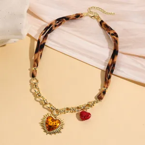 Detail shot of vintage leopard print necklace with gold chain and sun heart pendant for women.