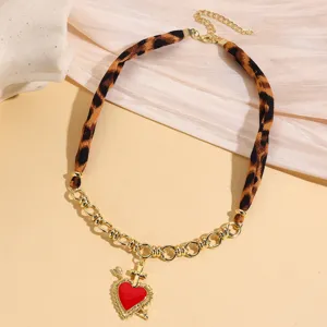 Chic retro leopard print fabric and gold chain choker necklace with red heart dagger pendant.