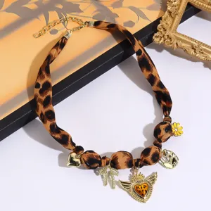 Vintage leopard print silk scarf necklace with gold charms, bow and heart pendant jewelry.