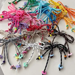 Colorful braided bow keychain bag charm details, vibrant dopamine style cute items.