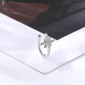 Silver star ear cuff and fake nose ring with sparkling zircon stones, delicate detail shot.