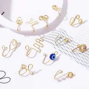 Detail shot of assorted golden non-piercing fake nose rings featuring geometric and eye designs.