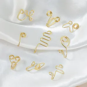 Close-up detail view of assorted gold wire non-piercing nose cuffs and vintage ear clips.