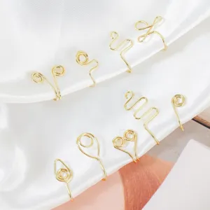 Close-up detail of gold non-piercing fake nose ring and ear cuff set with geometric wire designs.