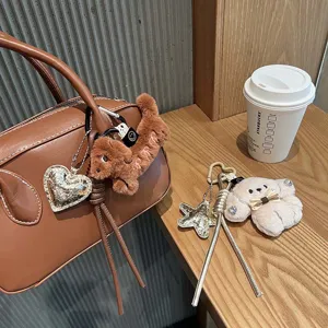 Cute plush dachshund puppy keychain bag charm with metallic heart pendant and braided rope.