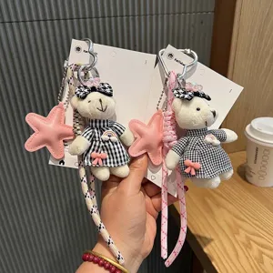 Detalle del llavero de peluche de oso a cuadros con lindo vestido y colgante de estrella.