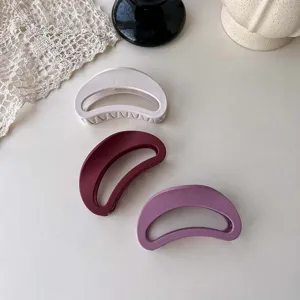 Detailed view of matte crescent hair claw, showing hollow design and smooth texture.