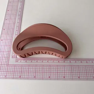 Detail view of the matte brown large crescent hair claw clip displayed on a measuring ruler.