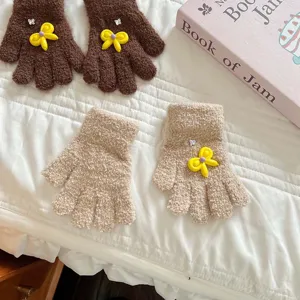 Detailed view of cute plush winter gloves with yellow bow and rhinestone, soft knitted fabric.