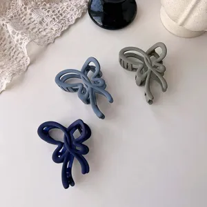 Matte hair claw clip detail, elegant bow design, durable grip for styling updo hair.