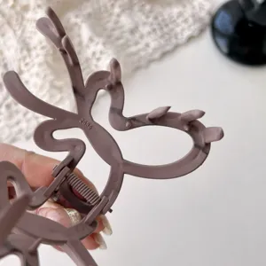 Close-up detail of a matte hair claw clip showing the spring structure and unique shape design.