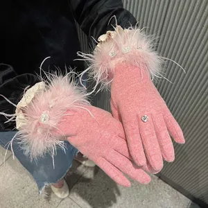 Vue détaillée de gants tactiles en cachemire rose pour femmes avec plumes et strass.