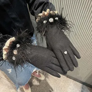 Gros plan détaillé de gants en tricot noir de luxe avec bordure en plumes et strass.