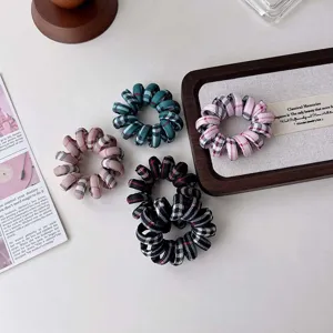 Gros plan de chouchous de téléphone à carreaux rétro en plusieurs couleurs, accessoires.