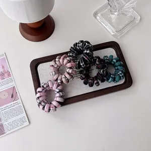 Gros plan sur les élastiques à cheveux en fil téléphone à carreaux rétro, accessoires.