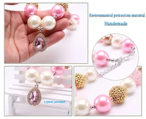 Gros plan detail du collier perle enfant avec pendentif larme en cristal rose style.