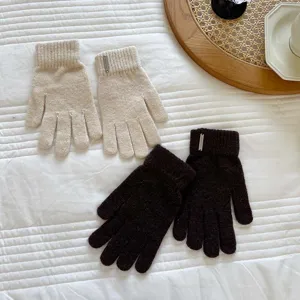 Detailed view of women autumn winter knitted gloves in beige and dark brown with metal tags.
