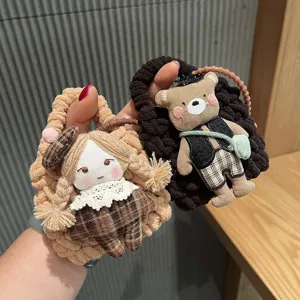 Handcrafted knitted cartoon doll bag charm and cute earphone storage pouch detail view.