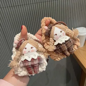 Close-up detail of handmade crochet doll bag pendant, cute plush coin purse and earphone pouch.