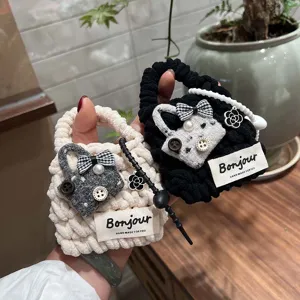 Handmade knitted plush earphone case detail, cute bow and pearl decoration, cozy style.