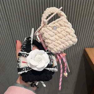 Detailed shot of handmade woven headphone case charm, featuring cute chunky knit and tweed design.