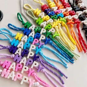 Colorful happy letter beaded braided strap detail view, cute bag charm and key accessory.