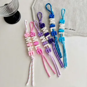 Colorful beaded braided rope keychain detail shot showing cute letter charms and nice craftsmanship.