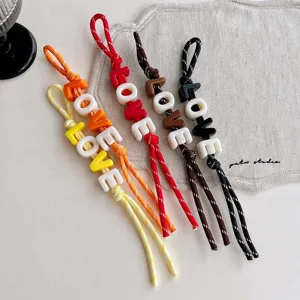 Detailed view of colorful dopamine style acrylic letter beaded braided rope bag charm, stylish.