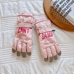 Close-up detail of pink winter ski gloves featuring waterproof fabric and touchscreen fingertips.