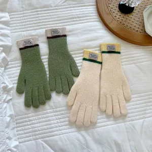 Cozy color-block knitted gloves detail shot, featuring split fingers and warm thick fabric.