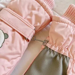 Dettaglio di guanti da sci termici rosa con fodera in peluche, palmo antiscivolo e polsini.