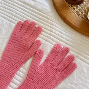 Vista dettagliata di guanti touch screen a costine rosa da donna, con trama morbida e vestibilità.
