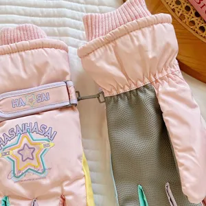 Pink thick warm ski gloves for winter with star pattern windproof knit cuffs details.
