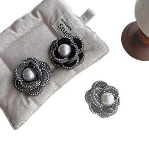 Elegant fabric camellia flower brooch with pearl center for womens fashion accessories.