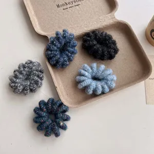 Detailed plush phone wire hair tie close up, soft knitted scrunchie for sweet casual styles.