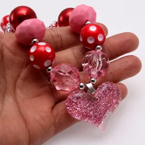 Collana bambina con ciondolo cuore glitter rosa, gioielli con perle grosse e rosse.
