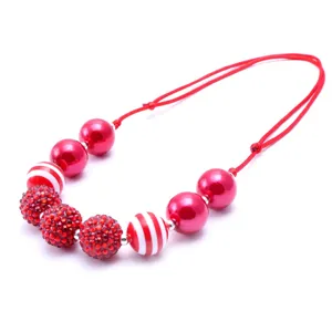 Detailed view of children's beaded necklace with resin rhinestone and striped balls.