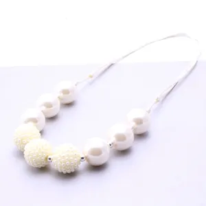 Close-up detail of children faux pearl beaded necklace with adjustable white cord design.